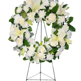 White floral wreath on a metal easel stand