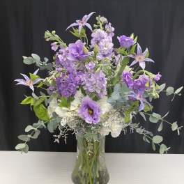 Purple and white bouquet in a clear glass vase