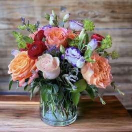 Mixed bouquet of roses and lisianthus in a clear glass vase
