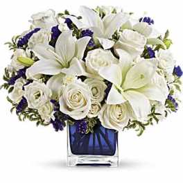 White lilies and roses in a blue glass vase
