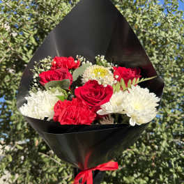 Bouquet of red roses and white chrysanthemums wrapped in black paper