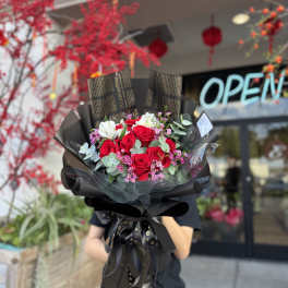 Bouquet of red roses with white blooms and pink filler flowers