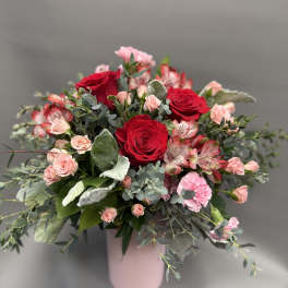 Pink and red rose bouquet in a pale pink vase