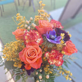 Bouquet of coral roses and purple flowers with yellow filler