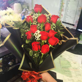Bouquet of red roses with baby's breath in black wrap and red ribbon