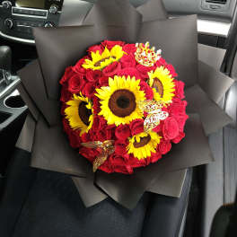 Bouquet of red roses and yellow sunflowers wrapped in black paper