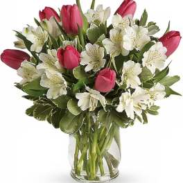 Pink tulips and white alstroemeria in a clear glass vase