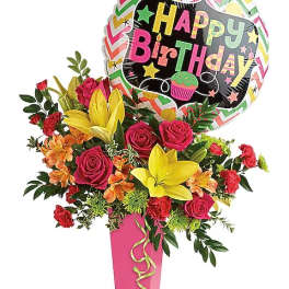 Birthday bouquet with roses, lilies, and a balloon in a pink vase