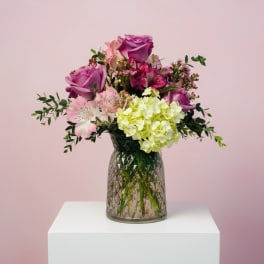 Pink and purple flower arrangement in a glass vase