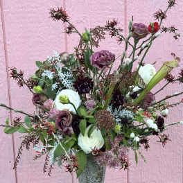 Mixed bouquet in a gray pedestal vase with white and purple blooms