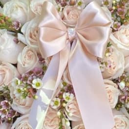 Bouquet of pale pink and white roses with a satin bow