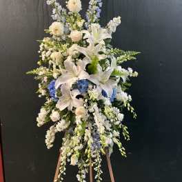 Tall white and blue floral standing spray on an easel