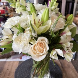 Bouquet of white and blush flowers in a clear glass vase