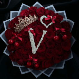 Heart-shaped bouquet of red roses with decorative crowns and cherries