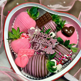 Heart-shaped box of chocolate-covered strawberries with pink decorations