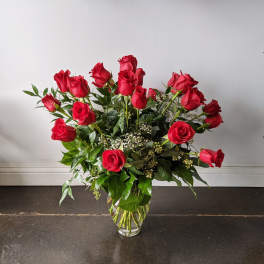 Red roses arranged in a clear glass vase