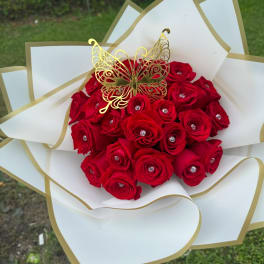 Red rose bouquet with a gold butterfly topper and white-gold wrapping