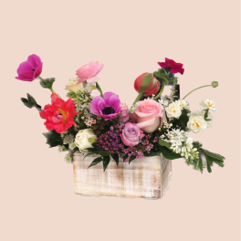 Mixed bouquet in a rustic wooden box with pink, red, white, and purple blooms