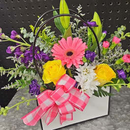 Mixed flower arrangement in a white box with a pink bow