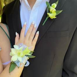 Boutonniere and wrist corsage with pale yellow flowers and ribbon