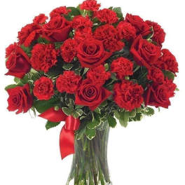 Red roses and carnations in a glass vase with a red ribbon