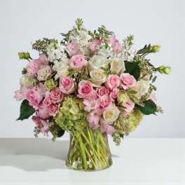 Pink and white rose bouquet in a clear glass vase