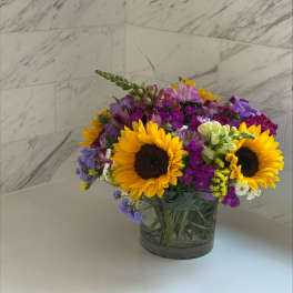 Mixed bouquet with sunflowers in a glass vase