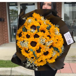 Bouquet of yellow sunflowers wrapped in black paper