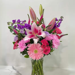 Pink and purple mixed bouquet in a clear glass vase