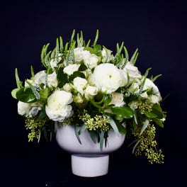 White floral arrangement in a white pedestal vase