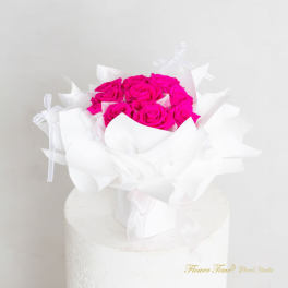 Bouquet of bright pink roses wrapped in white paper
