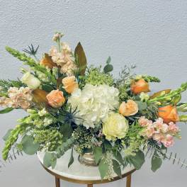 Mixed floral arrangement with peach roses and white hydrangea in a vase