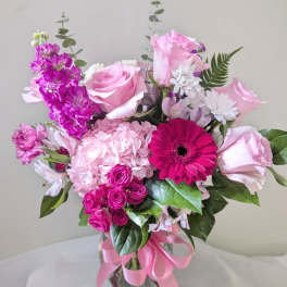 Pink and magenta mixed bouquet in a glass vase with a ribbon