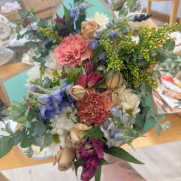 Hand-tied bouquet of mixed flowers in pink, white, and blue