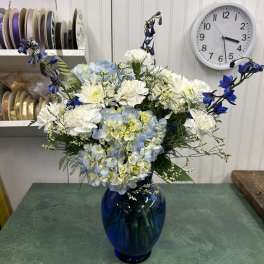Blue and white flower arrangement in a cobalt glass vase