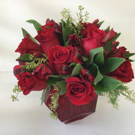Red rose bouquet with green foliage in a burgundy wrap