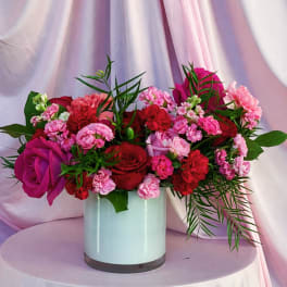 Pink and red flower arrangement in a white vase