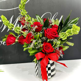Red roses in a checkered vase with a red ribbon
