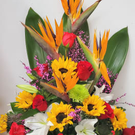 Tropical arrangement with red roses, sunflowers, and white lilies