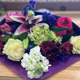 Mixed bouquet with lilies, roses, and hydrangea in purple wrap