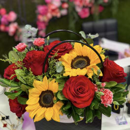Basket arrangement of red roses and sunflowers