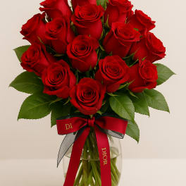 Bouquet of red roses in a clear glass vase with a red ribbon