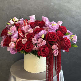 Large bouquet of red and pink roses in a white hat box