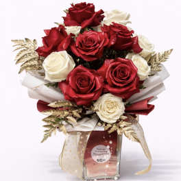 Bouquet of red and white roses in a clear glass vase with gold accents