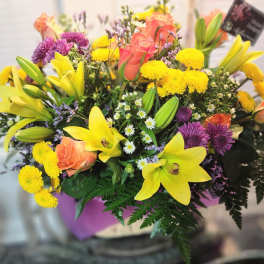 Mixed bouquet with yellow lilies, peach roses, and purple mums