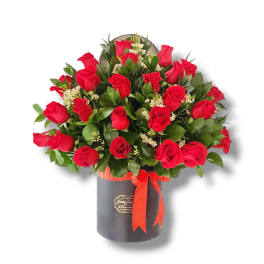 Bouquet of red roses in a black hatbox with a red ribbon