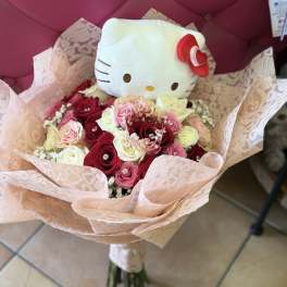Hello Kitty plush in a bouquet of pink and white roses