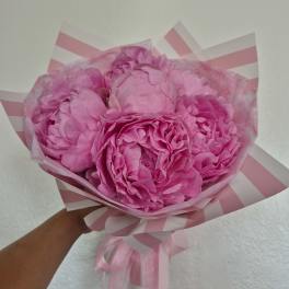 Bouquet of pink peonies wrapped in beige paper