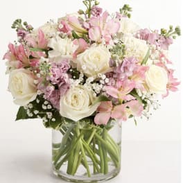 Pink and white bouquet of roses and lilies in a clear glass vase