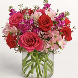 Bouquet of pink and red roses with pink alstroemeria in a clear glass vase